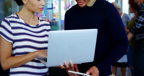 Colleagues Working Together on Laptop in Modern Workplace