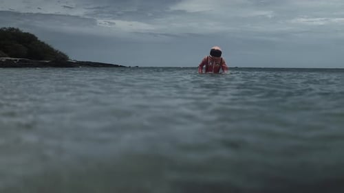 Astronaut Walks Through Ocean Water in Spacesuit
