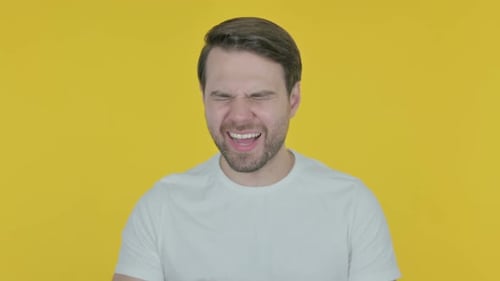 Man Experiencing a Headache on Yellow Background