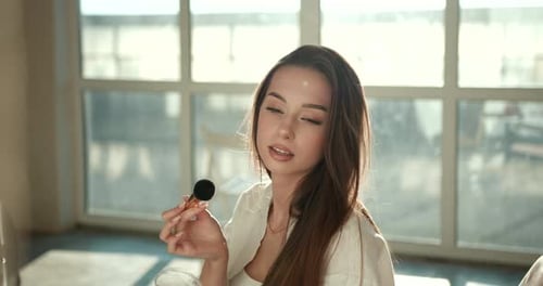 Beautiful Girl Doing Makeup with a Brush in Studio