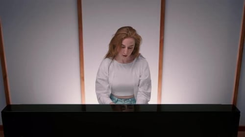 Close-up of the face: a woman sensually plays the piano