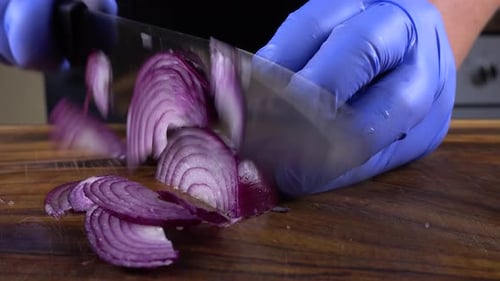 Chef Slicing Fresh Red Onion on Cutting Board