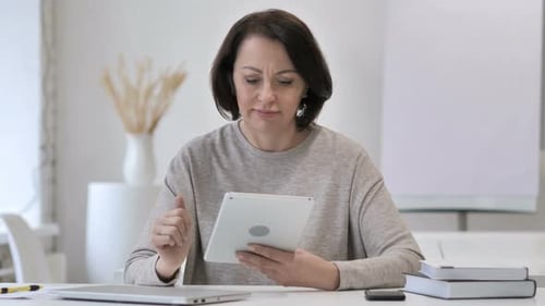 Woman Working on Tablet at Bright Desk