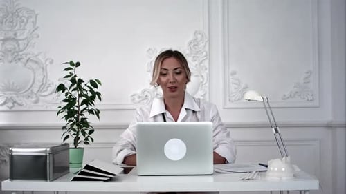Woman Using Laptop at Desk with Decorative Wall