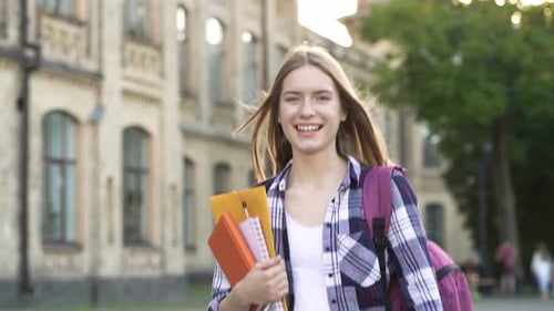 Pretty Young Woman Walking at The Park, Holding Textbooks