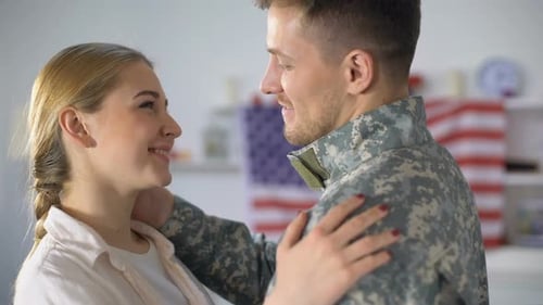 Soldier Embracing Smiling Woman at Home
