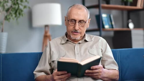 Senior Man Enjoys Reading a Book at Home
