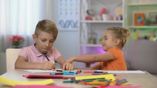 Boy and Girl Playing at Table with Markers