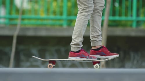 Teen Skateboarder Does Trick in Urban Skatepark