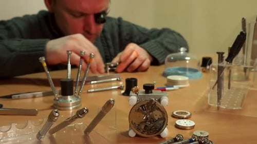 Male Watchmaker Repairing Wristwatch at Workplace