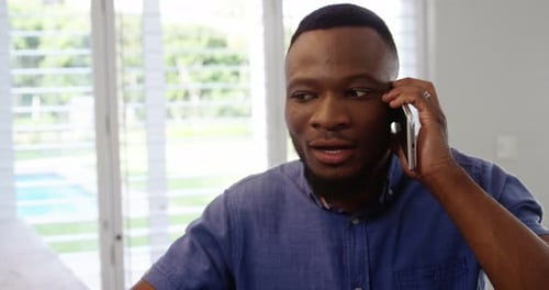 Man Talking on a Mobile Phone Indoors