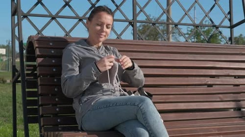 The Female Is Knitting in the Park
