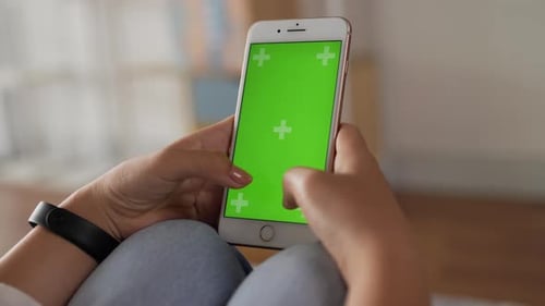 Closeup vertical of hand woman using smartphone with green screen