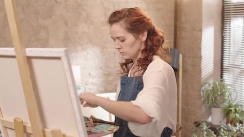 Curly Woman Painting in Studio