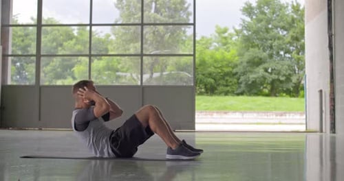 Junger erwachsener Mann macht Situps während des Fitness-Sporttrainings