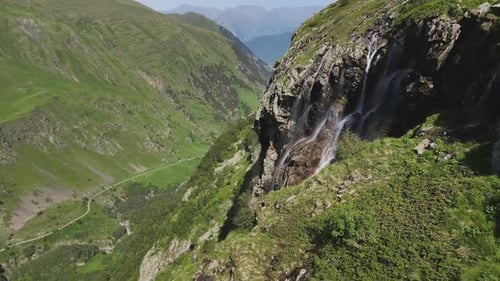 Water Flows Down the Slope of a Mountain Drops Splash From a Huge Rock