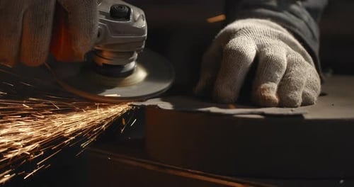 Locksmith Sands the Edges of a Metal Detail By Electric Grinder with a Lot of Sparks in Slow Motion