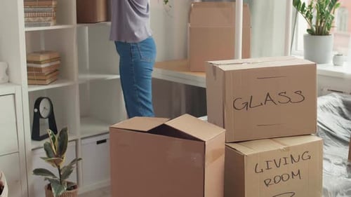 Couple Moving and Unpacking Boxes Indoors
