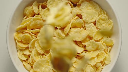 Milk Poured Over Bowl of Corn Flakes