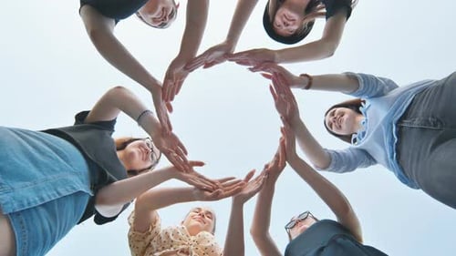 Friends Make a Circle with Their Palms Against the Blue Sky