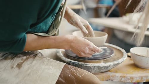 Zoom Out Shot of Woman Potter Making Ceramic Crockery on Pottery Wheel Slow Motion