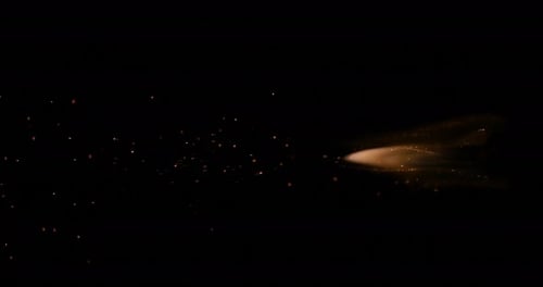 Golden Particles Streaming Across Black Background