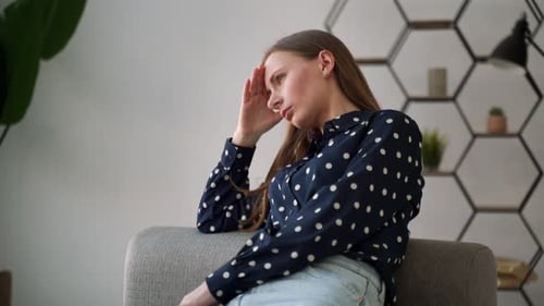 Woman Sitting on Couch Thinking Inside Home