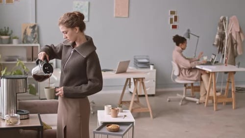 Designerin trinkt Kaffee im Büro