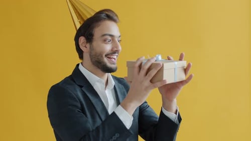 Slow Motion Portrait of Mixed Race Man Catching Gift Box and Smiling Enjoying Present