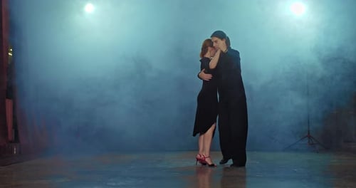 Beautiful Woman Dancing Romantic Tango with Elegant Man in Black Suit