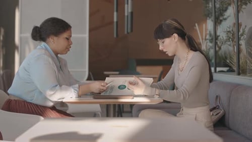 Women Collaborating on Business at Cafe Table