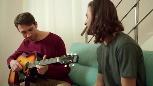 Friends Play Guitar and Sing Together Indoors
