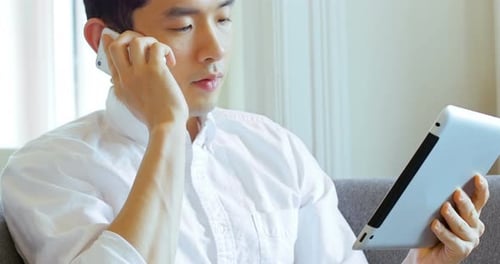 Young Adult Using Tablet and Talking on Phone