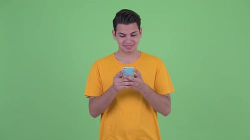 Young Adult Using Smartphone Against Green Background