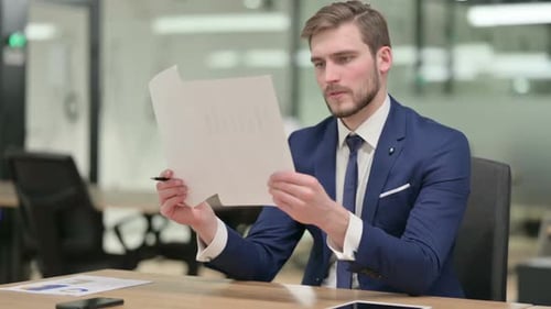 Businessman Reading Documents in Office