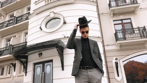Stylish Man Puts on Hat in City