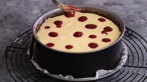 Preparing Delicious Cheesecake Dessert with Red Jam