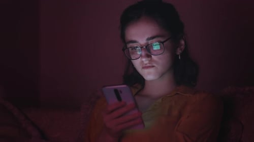 Woman Using Smartphone in Dark Home at Night