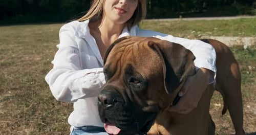Happy Woman Embraces Dog Friend in Sunny Park