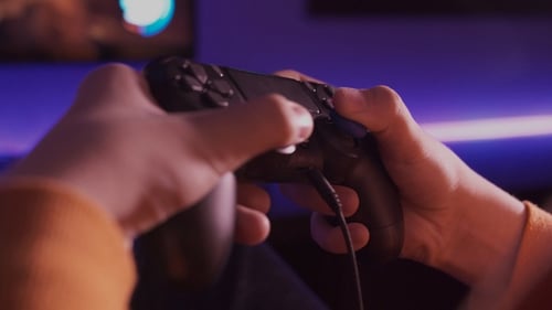 Hands Play Video Game with Controller in Blue Light