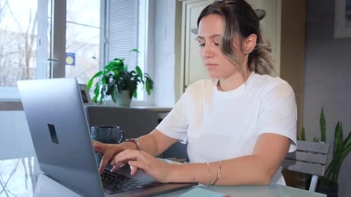 Woman Using Laptop in Bright Home Setting