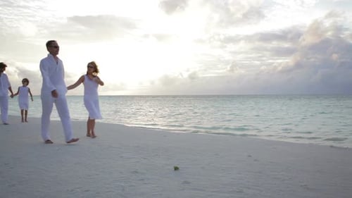 Family Walking Hand in Hand on Beach