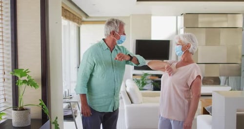 Seniors Bumping Elbows with Face Masks Indoors