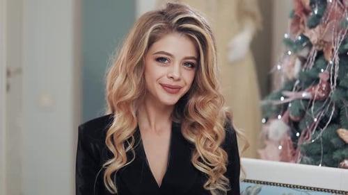 Smiling Woman with Blonde Hair Near Christmas Tree