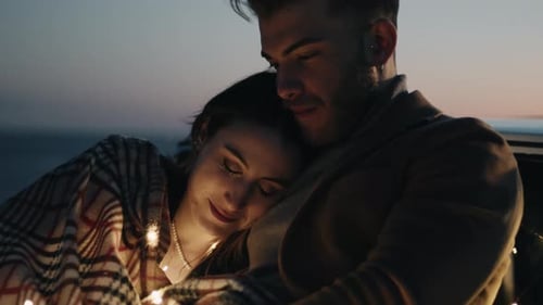 Affectionate Couple Embracing at Dusk by the Ocean