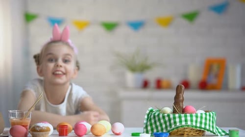Glückliches Mädchen lächelnd, schaut in die Kamera, wartet auf Ostern, letzte Vorbereitung