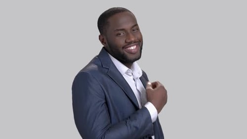 Confident Man in Suit Adjusts Collar and Smiles