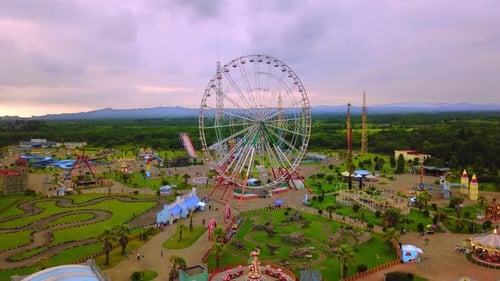 Top view of amusement park with Ferris wheel and roller coaster