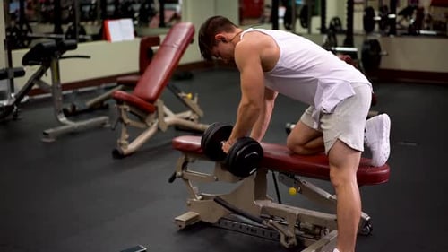 Young Man Lifting Weights in Gym
