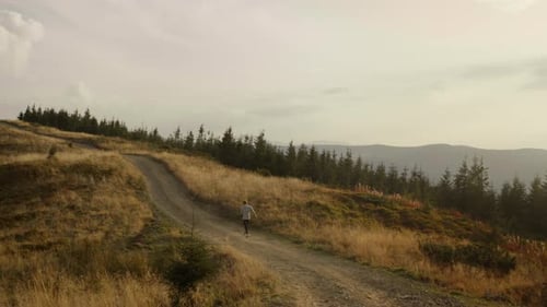 Jogger Running on Road in Mountains